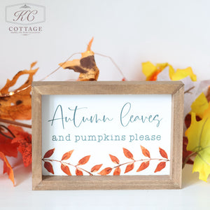 The Autumn Pumpkin Patch Signs feature a framed display with a wooden border, showcasing the phrase "Autumn leaves and pumpkins please" in elegant cursive and print fonts. The bottom of the sign is beautifully decorated with an illustration of a branch with orange leaves, making it ideal for enhancing your autumn decor. Brightly colored autumn leaves are scattered in the background to add an extra touch of seasonal charm.