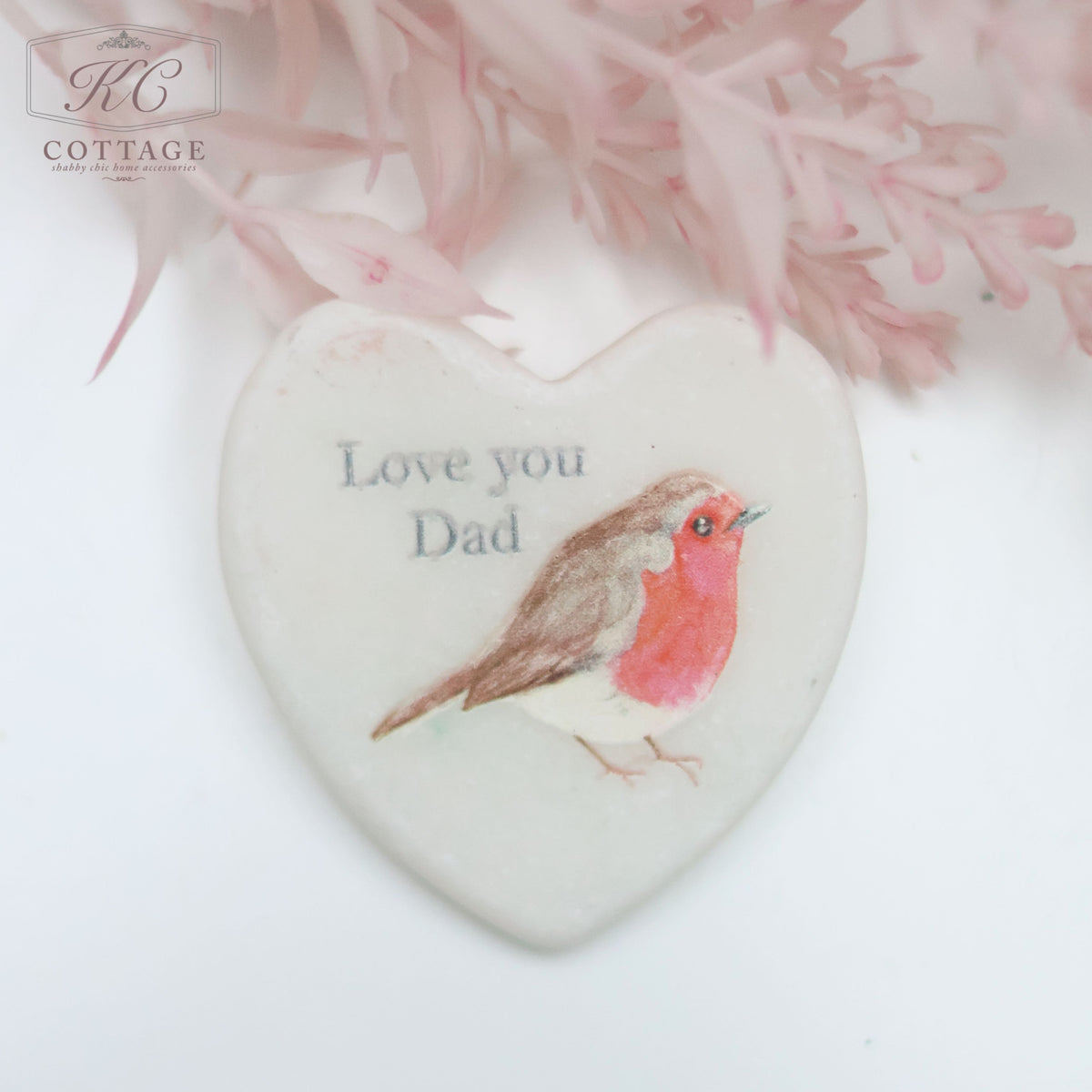 A Marble Pocket Pebble Robin Sentiment Heart featuring a watercolor-style robin bird design with the text "Love you Dad" above. The background includes soft pink flowers at the top, making it a charming piece of home decor.