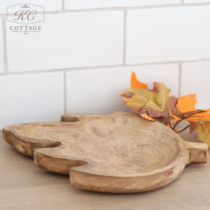 A Mango Wood Leaf Tray graces the countertop, contrasting beautifully with a backdrop of white subway tiles. Autumn leaves scattered in the background infuse the scene with a seasonal ambiance. This portrayal encapsulates cozy home decor and organic elegance, contributing to a rustic kitchen charm. In the top left corner, a watermark reads "KC Cottage.