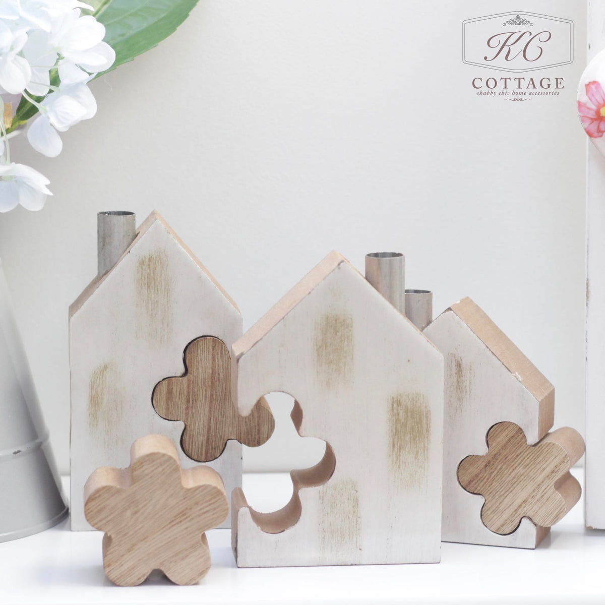 A decorative scene features the Wooden House Set with Flower Block, perfect for home decor. Each house has a flower-shaped cutout, and two wooden flower shapes are placed in front of them.