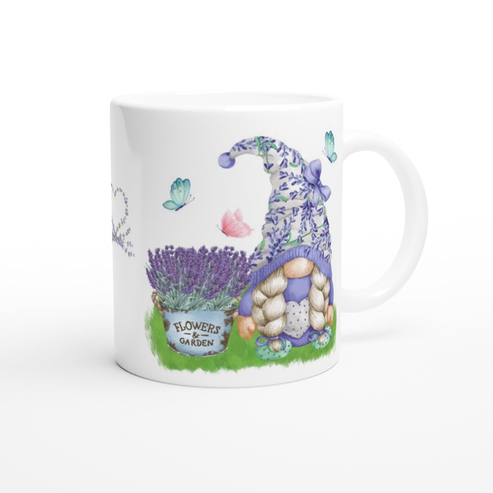 A white ceramic mug showcases a whimsical design of a gnome with braided blond hair wearing a blue, patterned hat, sitting beside a pot of lavender labeled "Flowers Garden." Butterflies flutter around in the background, making the Gonk Lavender & Butterfly Mug a charming piece of home decor.