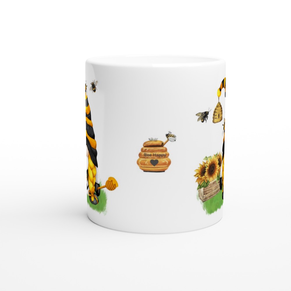 A white Bee & Sunflower Gonk Mug decorated with illustrated bees, honeycombs, sunflowers, and a honey jar labeled "Bee Happy." The design shows bees flying around the flowers and honeycombs, giving the mug a cheerful and lively look. This charming piece is perfect for adding a touch of whimsy to your home decor.